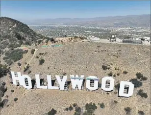  ?? Brian van der Brug Los Angeles Times ?? THE HOLLYWOOD sign gets a fresh coat of paint in October. It took decades after its 1923 iteration as Hollywoodl­and for the city to realize the cultural gem it had on its hands.