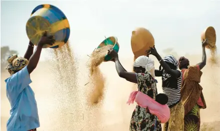  ?? JEROME DELAY/AP 2013 ?? Women sift wheat in Mali. U.S., French and Russian leaders have been crisscross­ing Africa to win support for their positions on Ukraine.