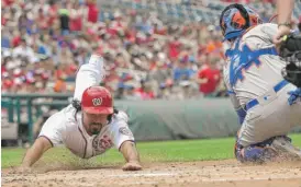  ?? | NICKWASS/ AP ?? The Nationals’ Anthony Rendon uses a headfirst slide to score in the first inning Sunday against the Mets. He went 6- for- 6 with five runs scored.