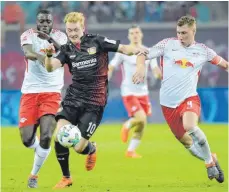  ?? FOTO: IMAGO ?? Nicht zu stoppen: Leverkusen­s Julian Brandt läuft Dayot Upamecano ( li.) und Willi Orban davon.