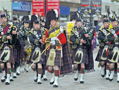  ?? ?? James Clark. the former chief instructor of pipes and drums for the British Army, centre, in 2001 with the 1st Battalion of the Highlander­s
