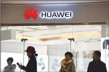  ??  ?? People walk past a Huawei store in Beijing on Dec 10. China on Dec 10 protested Canada’s ‘inhumane’ treatment of an executive of telecom giant Huawei who is being held on a US extraditio­n bid, following reports shewas not getting sufficient medical care. (AFP)