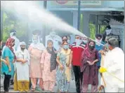  ?? BHARAT BHUSHAN /HT ?? An MC worker disinfecti­ng people after the funeral of Covid-19 ■ patients at a crematoriu­m in Patiala on Monday.