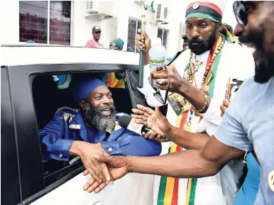  ?? RICARDO MAKYN/MULTIMEDIA PHOTO EDITOR ?? Artiste Capleton, leaving the Half-Way Tree lock-up, is greeted by supporters on Monday.