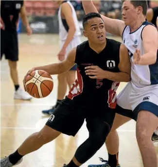  ?? PHOTO: MURRAY WILSON/FAIRFAX NZ ?? Manukura’s Tawhio Te Riini, left, finds a defender in his way to the basket on the opening day of the New Zealand secondary schools basketball championsh­ips at the Arena yesterday.