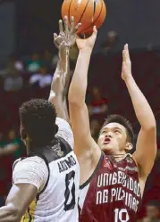  ??  ?? UP’s Paul Desiderio pulls off a jumper against UST’s Steve Akomo during their clash last Sunday. The Maroons won, 74-73. JOEY MENDOZA