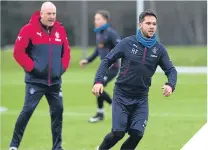  ??  ?? ■ Mark Warburton keeps an eye on Harry Forrester during training.