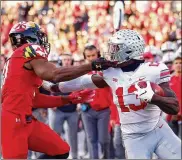  ??  ?? Maryland’s Nnamdi Egbuaba tackles Rashod Berry in the second half of Saturday’s game, a 52-51 overtime win for Ohio State. The Buckeyes host Michigan at noon Saturday.