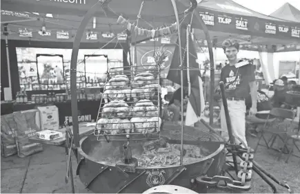  ?? STU BOYD II/THE COMMERCIAL APPEAL ?? Team Alfrugoni grills chicken on this huge rack in front of its booth , during the 2023 Memphis in May World Championsh­ip Barbecue Cooking Contest at Tom Lee Park in Downtown Memphis.