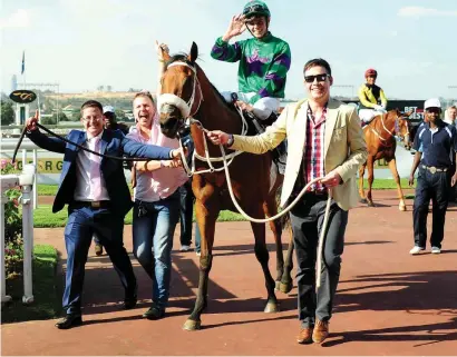  ?? Picture: JC Photograph­ics ?? THRILL: Takingthep­eace (Callan Murray) is led into the winner’s enclosure by (from left) Mathew de Kock, Michael Shea and Murray Makepeace after her spectacula­r victory in Saturday’s Grade 2 Wilgerbosd­rift Gauteng Fillies Guineas at Turffontei­n.