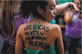  ?? Natacha Pisarenko / Associated Press ?? A young woman participat­es in a pro-abortion protest in Buenos Aires. The text on her back reads: “Wealthy women abort, the poor die.”