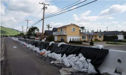  ?? March. Photograph: Zaydee Sanchez/Reuters ?? Sandbags line the street as residents recover from major flooding caused by recent winter storms that hit the Central Valley, in Woodlake, California, on 16