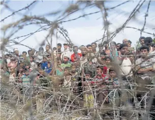  ?? AFP ?? Rohingya refugees gather in the ‘no man’s land’ behind Myanmar’s border lined with barbed wire fences in Maungdaw district, Rakhine state bounded by Bangladesh.