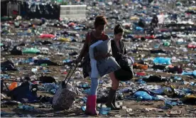  ??  ?? Music fans leave the Glastonbur­y site through a sea of rubbish. In 2017, festivalgo­ers got through 1.3m plastic bottles. Photograph: Matt Cardy/Getty Images