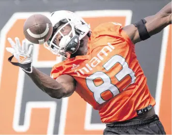  ?? AL DIAZ adiaz@miamiheral­d.com ?? Hurricanes wide receiver Michael Redding III makes a one-handed catch during the first day of fall practice at Greentree Practice Field at the University of Miami in Coral Gables on Friday.