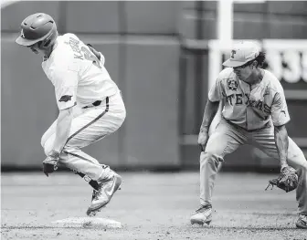  ?? Nati Harnik / Associated Press ?? Heston Kjerstad, left, and Arkansas got the best of shortstop David Hamilton and Texas on Sunday, sending the Longhorns into an eliminatio­n game showdown against Florida on Monday.