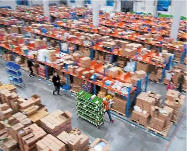  ?? ?? New landscape: Employees at a warehouse of Cainiao, alibaba’s logistics unit, in Wuxi, Jiangsu province. Online shopping symbolises new retail by enhancing transactio­n efficiency of commoditie­s. — reuters
nd