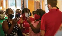  ?? ALYSSA POINTER / ALYSSA.POINTER@AJC.COM ?? Michelle Sheffield (left) of Snellville speaks last month in Atlanta to Cody Hall (right), press secretary for Gov. Brian Kemp, about the governor’s decision to not mandate the wearing of face coverings statewide.