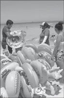  ??  ?? A la izquierda, pasajeros del crucero Carnival Triumph, que llegó de Cozumel, se retiran del malecón. Abajo, paseantes locales compran productos inflables en las playas de Progreso