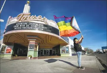  ?? Tomas Ovalle For The Times ?? RONNIE CASSIS hoists a pride f lag in February to protest a church’s purchase of a historic Fresno theater. Controvers­y arose again when officials disagreed over flying the flag at City Hall for LGBTQ Pride Month.