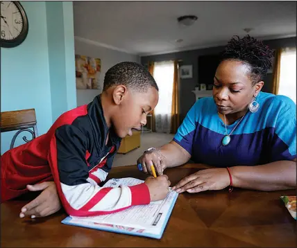  ?? ?? Above: Tamela Ensrud helps her son, Christian with his homework at their home in Nashville, Tenn. Left: Seven-year-old Christian watches as his mother points out a word in his workbook. Some parents are struggling to get clear informatio­n explaining how their children are performing or a school plan to help them catch up.