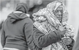  ?? Michael Ciaglo / Houston Chronicle ?? Michael Labingo wraps himself in blankets provided by the Star of Hope’s Love in Action van. The Houston area is expected to see a warming trend Wednesday, but nights will remain cold.