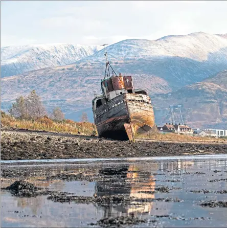  ?? ?? Ben Nevis, right, with a dusting of snow on the summit, looms over wreck of the Golden Harvest fishing