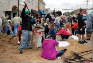  ?? The Associated Press ?? FILLING UP: Volunteers fill sandbags in an effort to protect buildings from potential floodwater­s Monday in Eureka, Mo. Torrential rain caused Missouri waterways to burst their banks over the weekend forcing hundreds of road closures and causing people to take precaution­s against possible flooding.