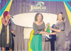  ??  ?? June Spence-Jarrett (left), executive director, JADCO presents a token to Dr Jody Ann Jarrett for responding correctly to a question about the anti-doping programme at JADCO’s Decennial Gala. In the background is Jennifer &amp;apos;Jenny Jenny&amp;apos; Small, master of ceremonies.