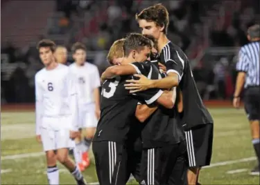  ?? AUSTIN HERTZOG - DIGITAL FIRST MEDIA ?? Boyertown players Alex Kidwell, left, Nathan Reinhard, Nik Verma and Kyle Sheahan embrace following the final whistle after Boyertown defeated Pottsgrove in the PAC boys soccer championsh­ip Thursday at Owen J. Roberts. Below, Boyertown’s Ben Vermeesch...