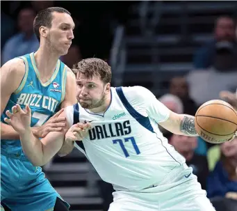  ?? ?? Charlotte Hornets forward Aleksej Pokusevski (17) guards Dallas Mavericks guard Luka Doncic (77) Tuesday during an NBA basketball game in Charlotte, N.C. (AP photo/jacob Kupferman)