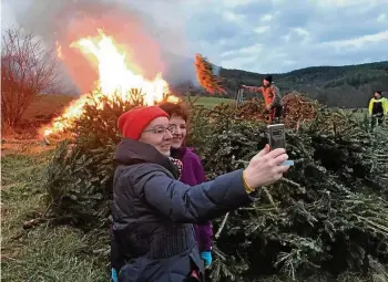  ?? THOMAS STRIDDE ?? Frauen mit Feuer: Martina Fiksel (links) und Heike Polt hielten sich im Selfiebild fest mit dem Drackendor­fer Knutfest-Feuer im Hintergrun­d.