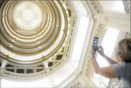  ??  ?? Gail Malloy, 57, of Greensburg takes a snapshot of the stained glass rotunda at the Union Trust Building on Saturday during the Doors Open Pittsburgh building tours.