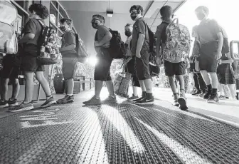  ?? Associated Press file photo ?? Students line up for the first day of school last month in Richardson. Gov. Greg Abbott ordered a ban on mask mandates by local officials, but many school districts have required the coverings.