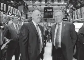  ??  ?? Interconti­nental Exchange Chairman and CEO Jeffrey Sprecher (left) and New York Stock Exchange CEO Duncan Niederauer on the floor of the New York exchange Thursday. Four members of the NYSE board will be added to ICE’s board, expanding it to 15...