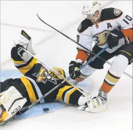  ?? John Heller Associated Press ?? PITTSBURGH PENGUINS goalie Marc-Andre Fleury, left, stops a shot by the Ducks’ Corey Perry in the first period. Fleury made 33 saves on Saturday.