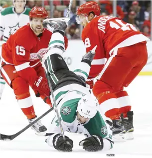  ??  ?? DETRIOT: Dallas Stars left wing Jamie Benn (14) is checked by Detroit Red Wings center Joakim Andersson (18) in the third period of an NHL hockey game, Sunday in Detroit. — AP