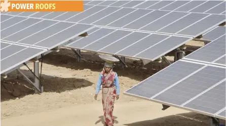  ?? — Reuters ?? A woman walks through the installed solar modules at the Naini solar power plant in the northern Indian city of Allahabad.