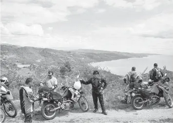  ??  ?? Bikers take a break by the roadside during the Visayan leg of their tour.