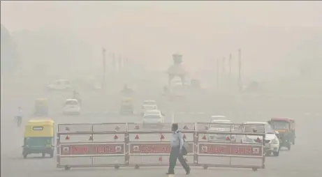  ?? SONU MEHTA/HT PHOTO ?? A pedestrian walks through smog at Raisina Hill on Monday.