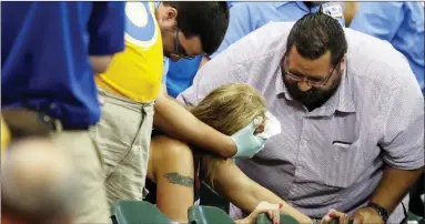  ?? AP FILE PHOTO BY MORRY GASH ?? In this July 6, 2015, file photo, a fan is helped after being hit by a foul ball during the ninth inning of a baseball game between the Milwaukee Brewers and the Atlanta Braves in Milwaukee. Illinois’ two senators have urged Major League Baseball to be more transparen­t about fans who are injured by foul balls, saying the lack of data is creating confusion about the extent of the problem. Democratic Sens. Dick Durbin and Tammy Duckworth said in a letter to baseball Commission­er Rob Manfred this week that MLB should “collect and report data about fan injuries.”