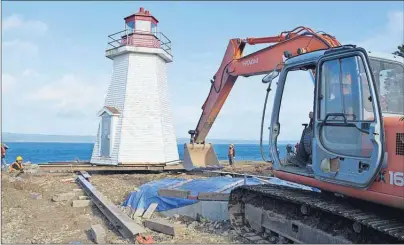  ?? GREG MCNEIL/CAPE BRETON POST ?? T&J Demeyere Properties carried out the complicate­d move of the Gabarus Lighthouse on Friday. The 125-year-old structure was moved from cliffside to a secure frost wall, using a combinatio­n of heavy equipment, rails and even dish detergent to ensure a...