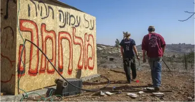  ?? (Marc Israel Sellem/The Jerusalem Post) ?? ‘THERE WILL be war over Amona,’ the graffiti reads at the outpost in the Binyamin region of Samaria on Friday.