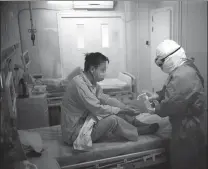  ?? PENG ZIYANG / XINHUA YAN TONG / FOR CHINA DAILY ?? Right: A nurse disinfects a patient at the hospital.