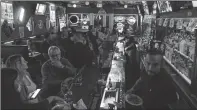  ?? Matt McClain/Washington Post (above); Ricky Carioti/The Washington Post (left) ?? ABOVE: Little Longhorn Saloon owner Terry Gaona cleans up chicken droppings.
LEFT: Bartenders and managers Cesar Salinas, foreground, and Mario Roselli, rear, work the bar at the Subway Inn.