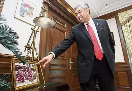  ??  ?? Then and now: Dr Ahmad Zahid was a student leader when studying in Universiti Malaya. He is seen here with a photograph of his undergradu­ate days and a framed report from ‘ The Star’ shortly after he was appointed as Deputy Prime Minister.