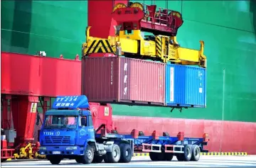  ?? — AFP photo ?? Containers are transferre­d at a port in Qingdao in China’s eastern Shandong province. Punishing US tariffs on Chinese imports took effect on July 6, the first shot in what Beijing called “the largest trade war in economic history” between the world’s...