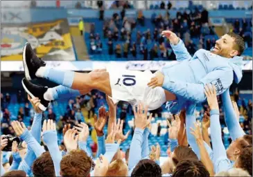  ?? AFP ?? Players lift Manchester City’s striker Sergio Aguero aloft during the trophy award ceremony on May 23.