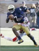  ?? CHARLES REX ARBOGAST — THE ASSOCIATED PRESS ?? Notre Dame quarterbac­k Brandon Wimbush breaks out of the grasp of Miami (Ohio) defensive back Matt Merimee Saturday in South Bend, Ind.