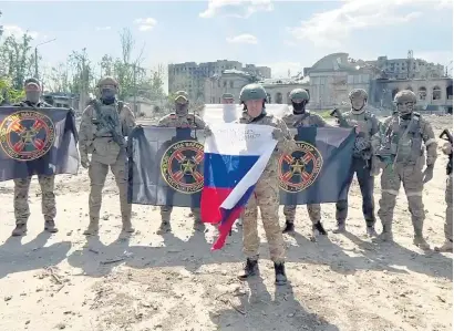  ?? I
AFP ?? Yevgeny Prigozhin posa en Bajmut con la bandera rusa delante de mercenario­s del grupo Wagner.
